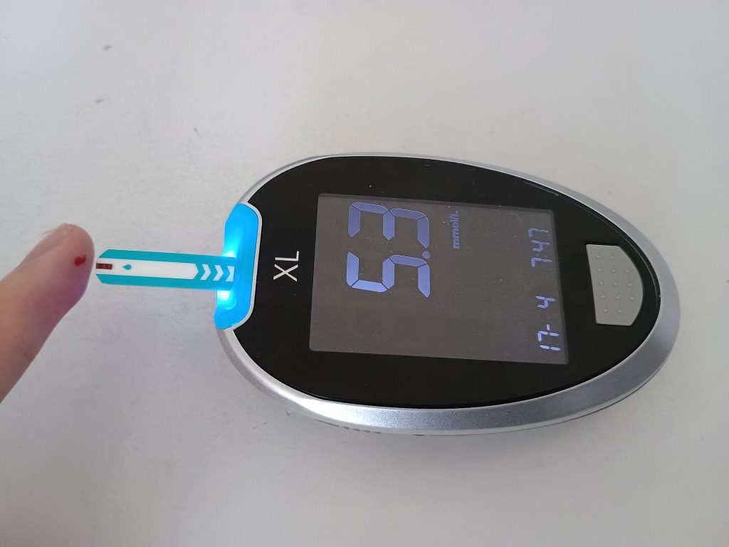 Continuous Glucose Monitors Give Type 2 Patients Five More Good Hours a Day Person checking a blood glucose reading on a small digital meter