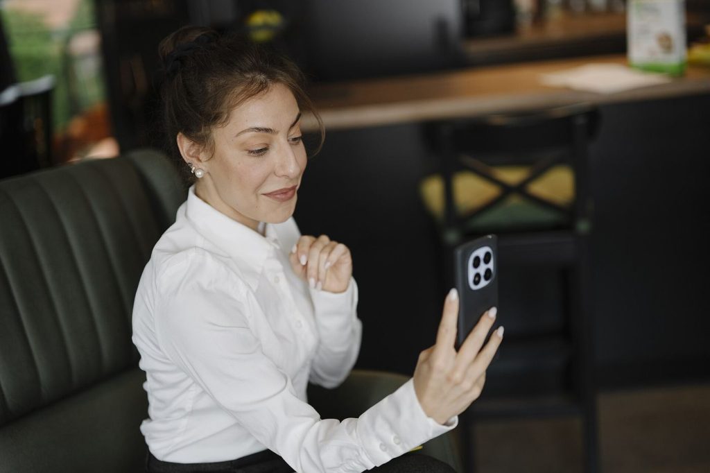 Deepfake Scams Move From Celebrities to the Family Group Chat A woman looking at her smartphone during a video call at home