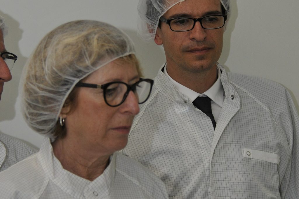 Semiconductor cleanroom engineer inspecting silicon wafers at a chip factory
